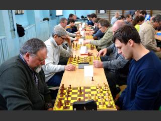 Turniej szachowy. Pary przeciwników siedzą nprzeciwko siebie i grają w szachy
