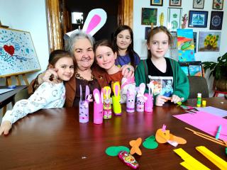 Dzieci z Króliczkiem Wielkanocnym - Pani Irenka. Przed nimi na stole kroliczki wykonane przez dzieci.