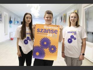 Trójka nastolatków z plakatem "Równać Szanse"