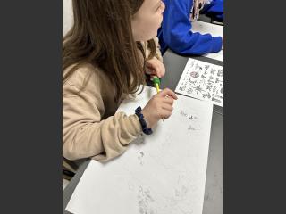 Dziewczynka przy stole podczas rysowania mapy.