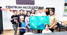 Dzieci z Centrum Młodzieżowego ze zrobionym przez siebie plakatem STOP PRZEMOCY