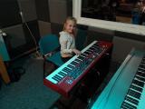 W studiu nagrań na Polanie Kultury dziewczynka gra na keyboardzie.