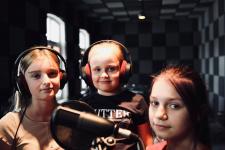 W studiu nagran trzy dziewczynki, przed nimi mikrofon.