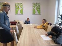 Dzieci w sali w Pałacu Kultury w orzyszu podczas zajęć z języka angielskiego. Dzieci siedzą przy stole, przed nim kartki. Z lewej strony Pani Dyrektor Polany Kultury- Joanna Kamieniecka.