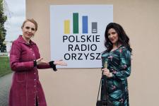 Joanna Kamieniecka oraz Skrzypaczka elektryczna - Ilona Perz-Golka, między nimi logo Polskiego Radia Orzysz