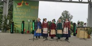 Kobiety z zespołu Orzyszanki w strojach ludowych na scenie podczas występu.