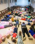 Dzieci leżą na podłodze w pawilonie Sosnowym na Polanie Kultury w Orzyszu.