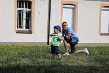 Mężczyzna z malym chłopcem. Chłopiec trzyma w ręku zielone frisbee.