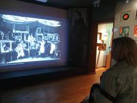 W Muzeum Konstantego Ildefonsa Gałczyńskiego. Kobieta oglada wyświetlany na ścianie film.
