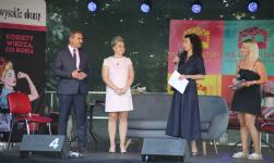 Na scenie Burmistrz Orzysza, Przewodnicząca Rady Miejskiej oraz dwie kobiety z Fundacji Wysokich Obcasów. Za nim na scenie kanapa.