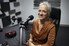 Monika Dąbkowska w studiu Polskiego Radia Orzysz. Przed nim statyw mikrofonowy.