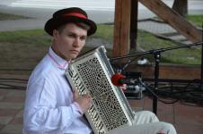Młody mężczyzna w stroju ludowym gra na akordeonie