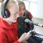 Dwie dziewczyny w studiu Radia Orzysz, przed nimi statyw mikrofonowy 