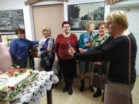 Kobiety z Klubu Seniora w Orzyszu w Muzeum w Orzyszu. Przed nimi na stole tort.