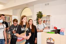 Grupa nastolatków stoi przy biurku w dziale dla dorosłych