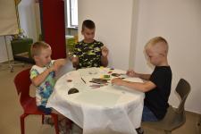 Dzieci siedzą przy stoliku i rysują