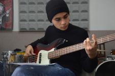 Chłopak grający na gitarze w studiu nagrań.