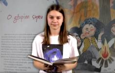 Dziewczyna pozuje do zdjeci z książką